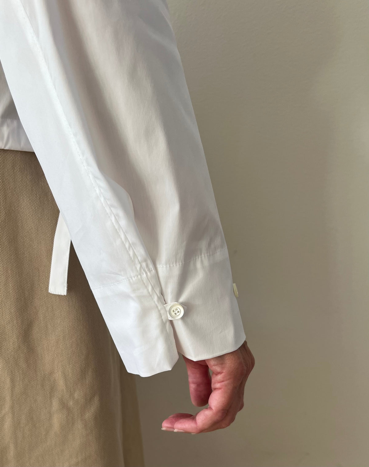 button in of a wide sleeve in white cotton  poplin